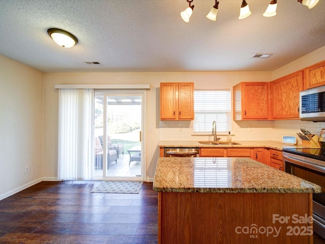 kitchen featuring a sink, dark wood-style floors, visible vents, and stainless steel appliances