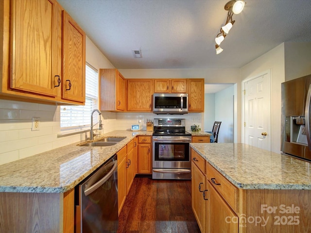 kitchen with light stone countertops, visible vents, dark wood finished floors, a sink, and appliances with stainless steel finishes