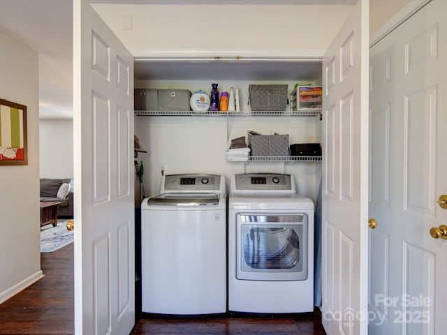 laundry area with washer and dryer, baseboards, wood finished floors, and laundry area