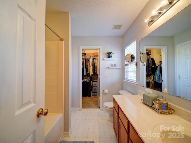 bathroom with visible vents, toilet, vanity, tile patterned floors, and a textured ceiling