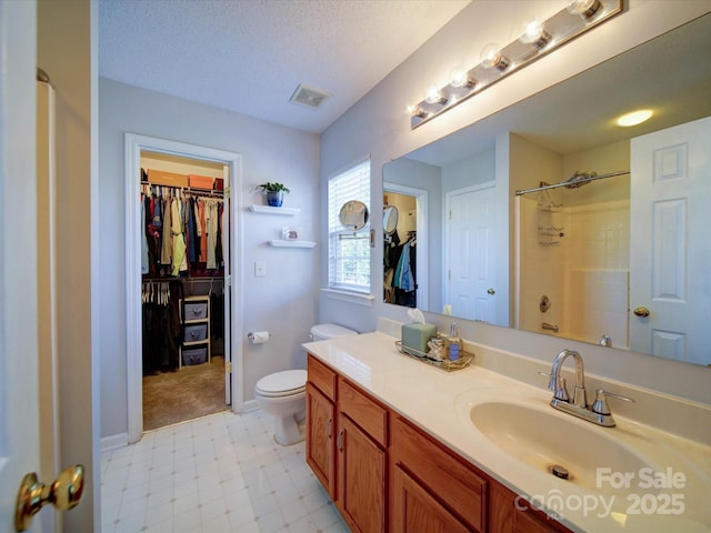 bathroom with visible vents, a walk in closet, toilet, a textured ceiling, and walk in shower