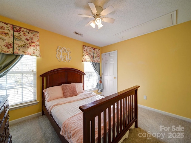 bedroom featuring visible vents, a textured ceiling, carpet, baseboards, and attic access