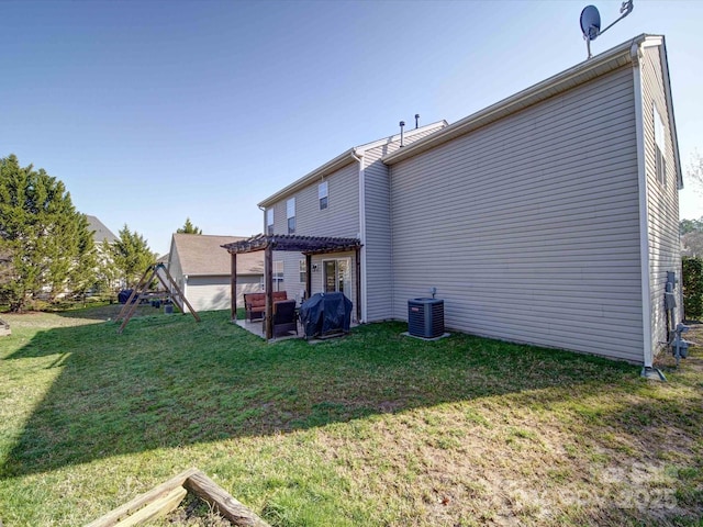 back of house with a playground, central AC unit, a yard, a pergola, and a patio