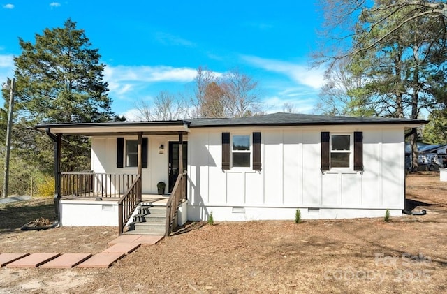 view of front facade featuring a shingled roof, a porch, board and batten siding, and crawl space