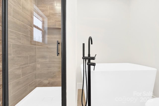 full bathroom featuring a sink, a soaking tub, and a stall shower