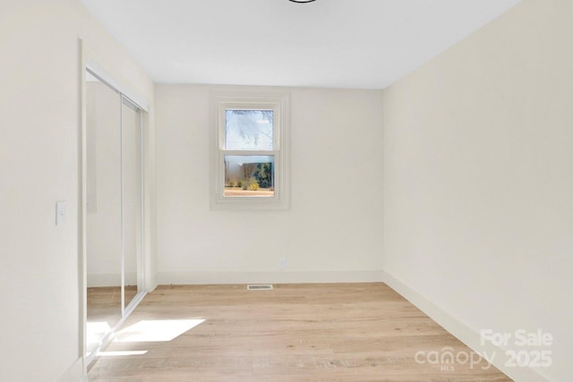 unfurnished bedroom with visible vents, baseboards, a closet, and light wood finished floors