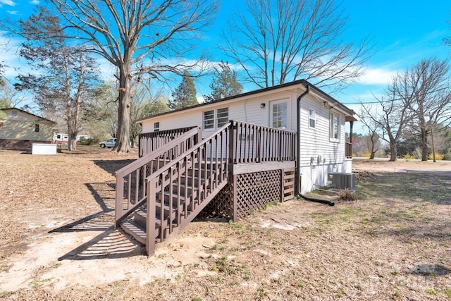 rear view of property featuring central air condition unit, stairway, and a deck