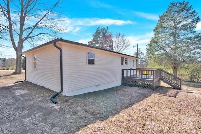 view of side of home with crawl space and a deck