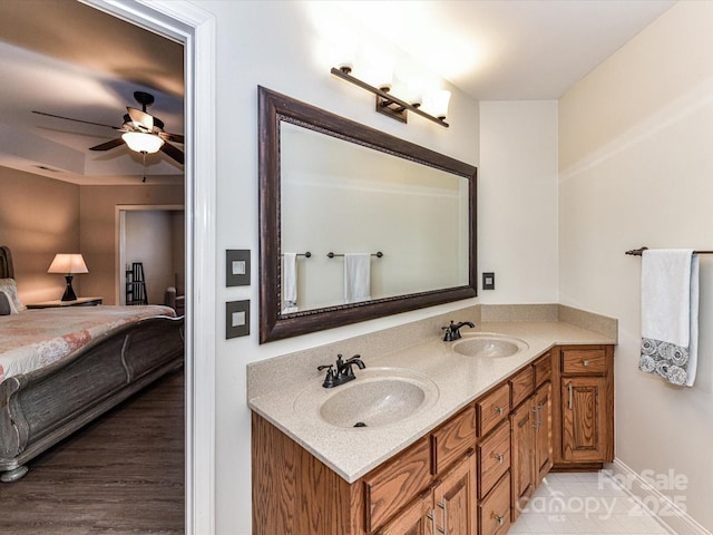 bathroom with double vanity, ensuite bath, a ceiling fan, and a sink