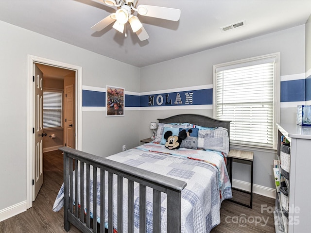 bedroom with visible vents, a ceiling fan, baseboards, and wood finished floors