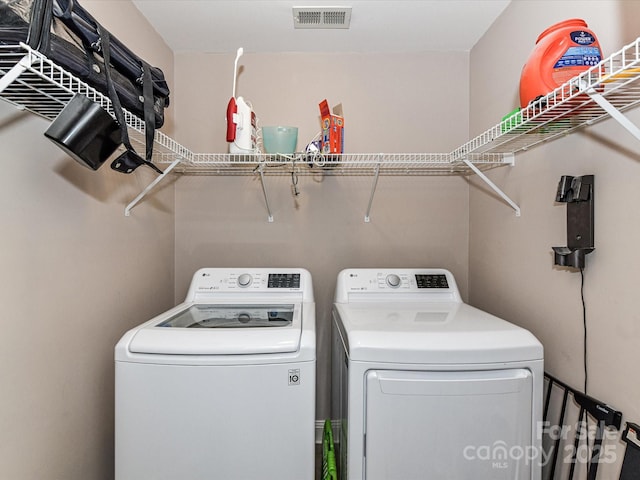 laundry area with laundry area, separate washer and dryer, and visible vents