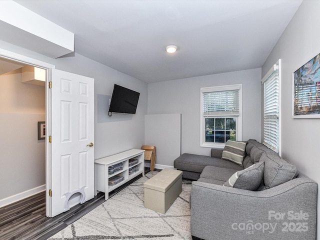 living area featuring baseboards and wood finished floors