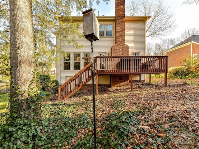 back of property featuring a deck, stairs, and a chimney