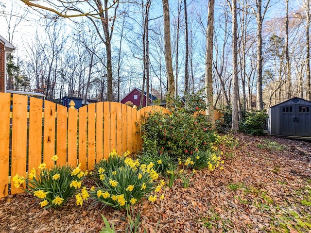 view of yard with a storage shed, an outdoor structure, and fence