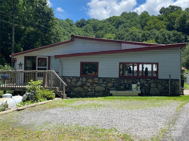 895 Laurel Valley Rd, Mars Hill, NC 28754 - view of front of house with stone siding, a deck, and a wooded view