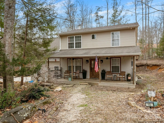 view of front of home featuring stucco siding, a porch, and roof with shingles