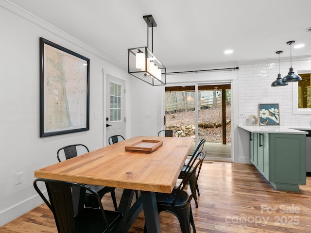 dining space featuring crown molding, recessed lighting, light wood-style floors, and baseboards