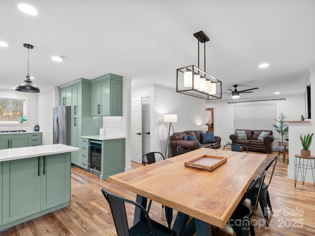 dining area featuring a ceiling fan, recessed lighting, beverage cooler, and light wood-style floors