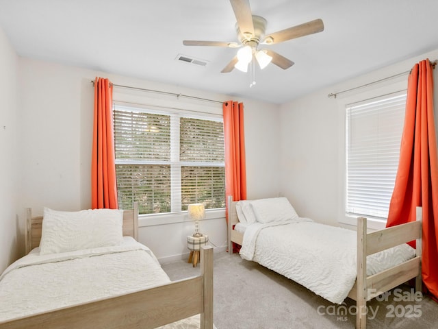 carpeted bedroom featuring visible vents, baseboards, and ceiling fan