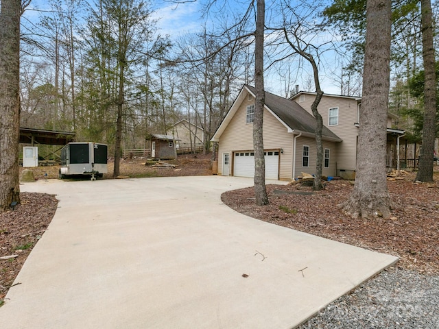 view of side of property featuring concrete driveway