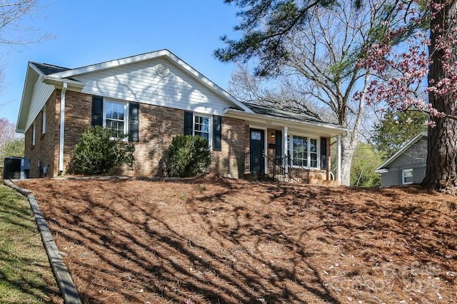 ranch-style house featuring central AC unit and brick siding