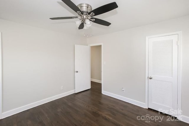 unfurnished bedroom with a ceiling fan, baseboards, and dark wood-style flooring