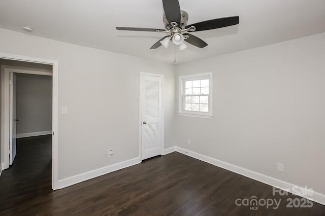 unfurnished room with ceiling fan, baseboards, and dark wood-style flooring