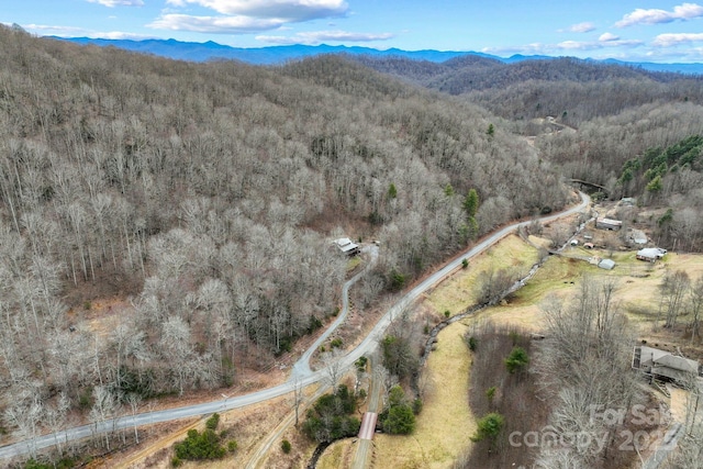 drone / aerial view featuring a mountain view and a view of trees