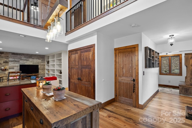 living room featuring a high ceiling, light wood-style floors, and baseboards