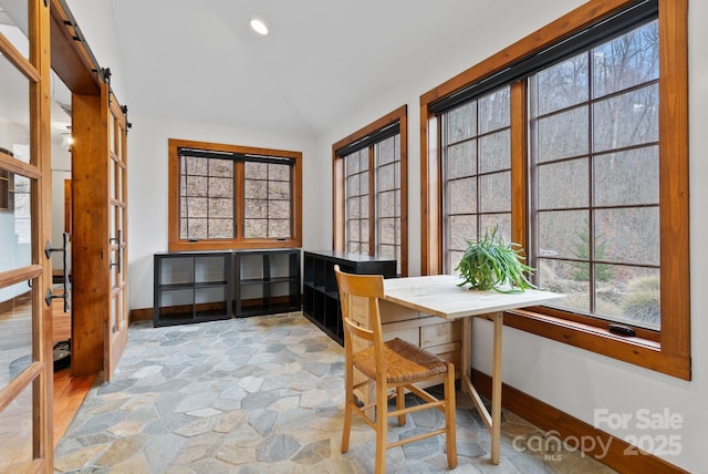 office area featuring a barn door, recessed lighting, baseboards, and stone finish flooring