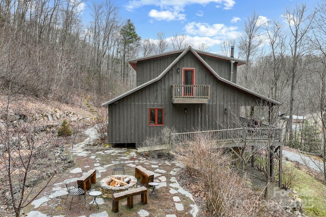 view of side of home featuring a barn and a fire pit