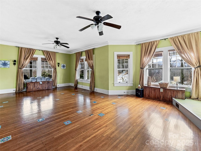 unfurnished living room with baseboards, wood-type flooring, ornamental molding, and a ceiling fan