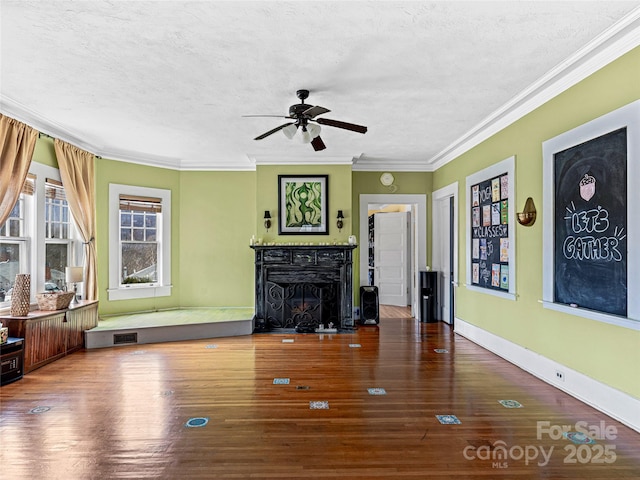 unfurnished living room with wood finished floors, ornamental molding, a fireplace, and a textured ceiling