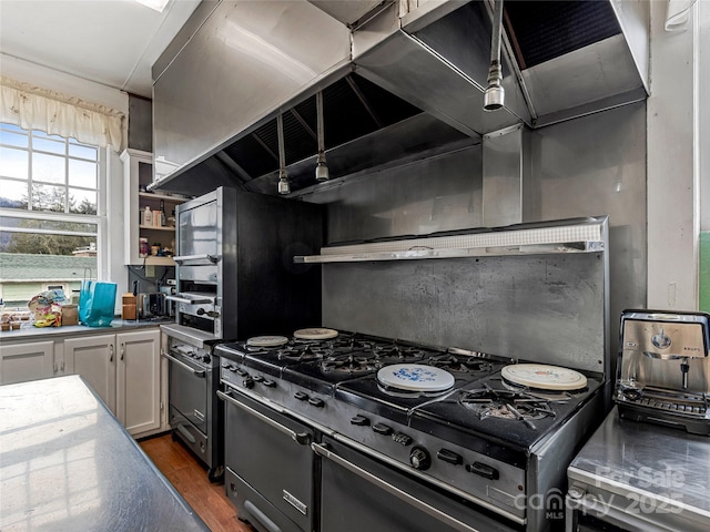 kitchen with dark wood finished floors, stainless steel gas range, and open shelves