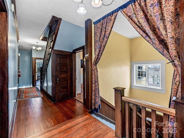 hallway featuring an upstairs landing, wainscoting, and hardwood / wood-style flooring