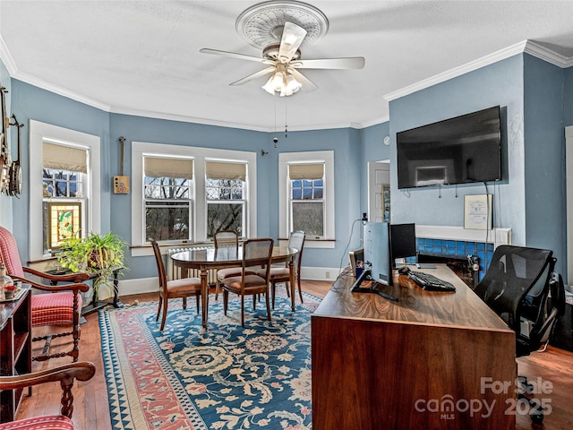 office area featuring baseboards, wood finished floors, ornamental molding, and a ceiling fan