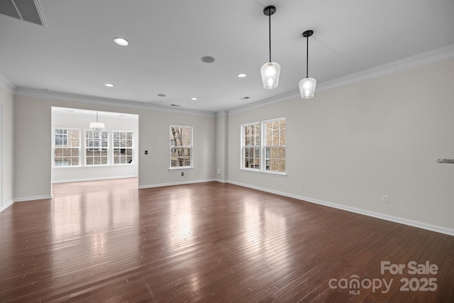 unfurnished living room with hardwood / wood-style flooring, baseboards, visible vents, and ornamental molding