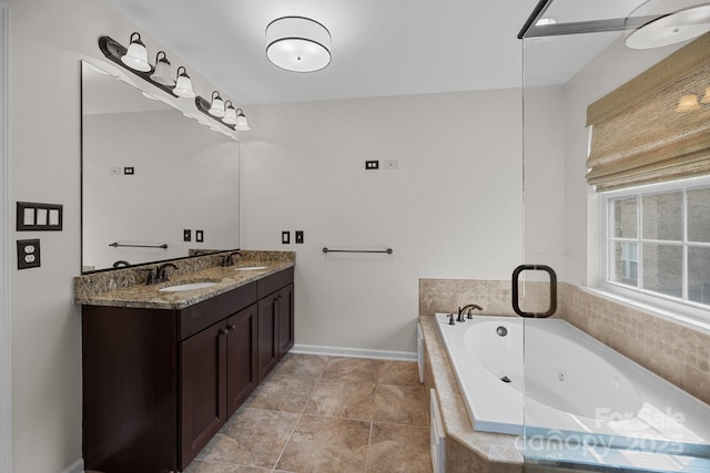 full bath featuring double vanity, a jetted tub, baseboards, and a sink