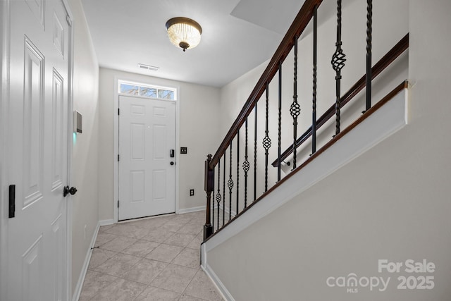 entrance foyer featuring visible vents, baseboards, and stairway