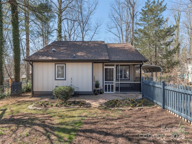 view of front facade featuring roof with shingles, a front lawn, and fence