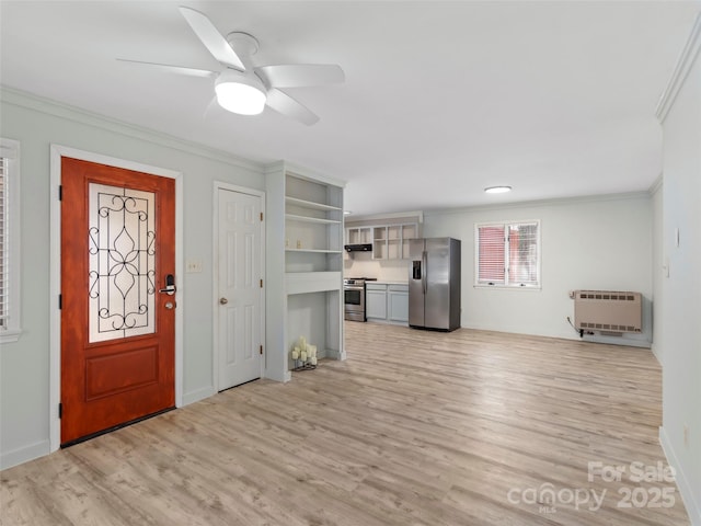 foyer featuring crown molding, baseboards, ceiling fan, light wood-style flooring, and heating unit