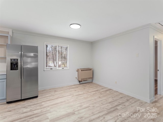 interior space featuring heating unit, light wood-style floors, ornamental molding, and stainless steel fridge with ice dispenser