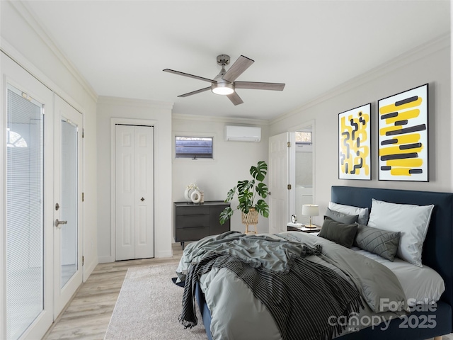 bedroom featuring light wood finished floors, crown molding, a wall mounted AC, and ceiling fan