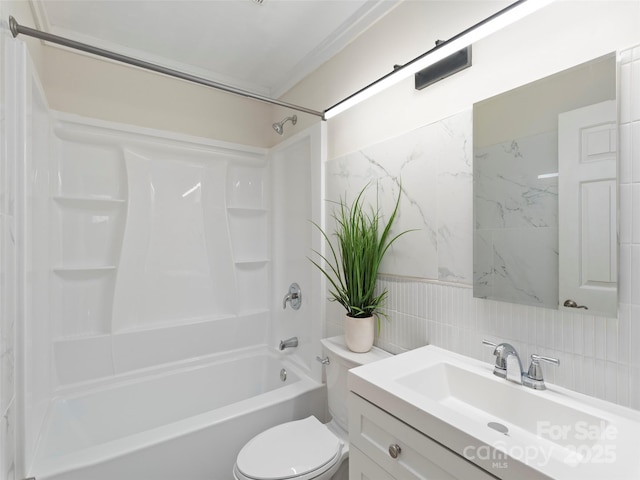 bathroom featuring toilet, tasteful backsplash, shower / tub combination, tile walls, and vanity