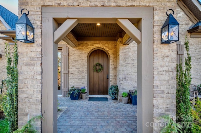 view of exterior entry with brick siding