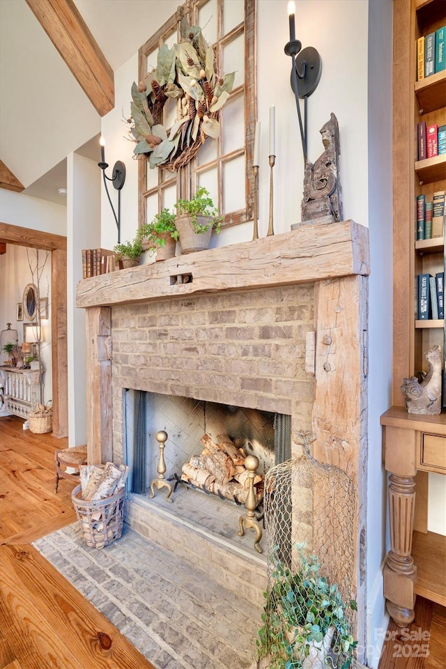 details featuring wood finished floors, a fireplace, and beam ceiling