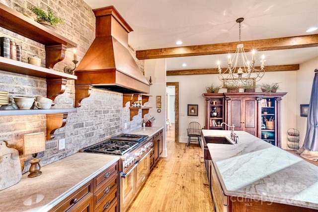 kitchen with light wood finished floors, open shelves, a sink, tasteful backsplash, and island range hood