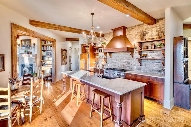 kitchen with open shelves, light wood-type flooring, custom exhaust hood, and high end range