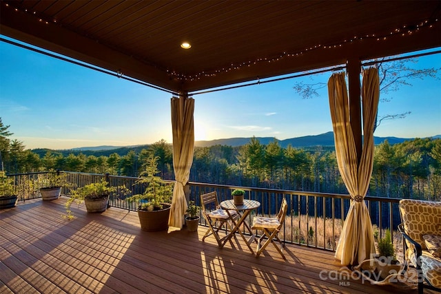 deck featuring a forest view and a mountain view