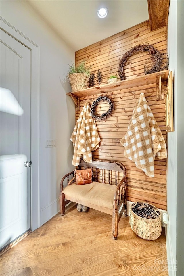 sitting room with wooden walls and wood finished floors